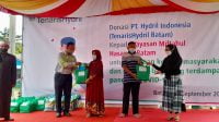 Perwakilan dari Tenaris Batam dan Panti Asuhan Miftahul Hasanah membagikan paket sembako secara simbolis ke masyarakat setempat. ist