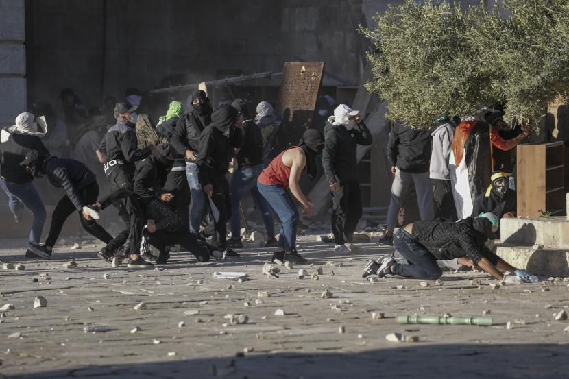 Warga Palestina bentrok dengan pasukan keamanan Israel di kompleks Masjid Al Aqsa di Kota Tua Yerusalem Jumat (15/4/2022). Foto: AP/Mahmoud Illean