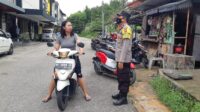 Seorang pengendara sepeda motor terpaksa dihentikan oleh petugas dan diberikan peringatan agar senantiasa menggunakan masker saat berada di luar rumah. foto endang