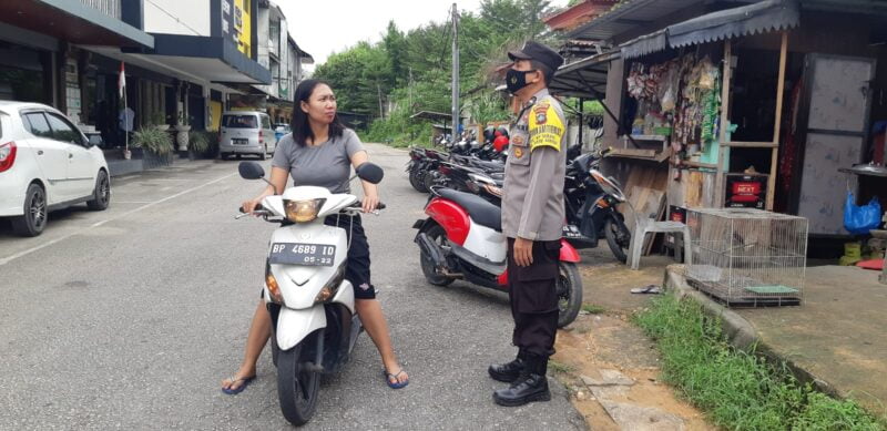 Seorang pengendara sepeda motor terpaksa dihentikan oleh petugas dan diberikan peringatan agar senantiasa menggunakan masker saat berada di luar rumah. foto endang