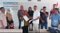 Sekretaris DPC Gerindra Kota Batam, Aweng Kurniawan menyerahkan secara simbolis bantuan pendidikan ke salah seorang orang tua Siswadi Batam. Foto Gerindra Batam